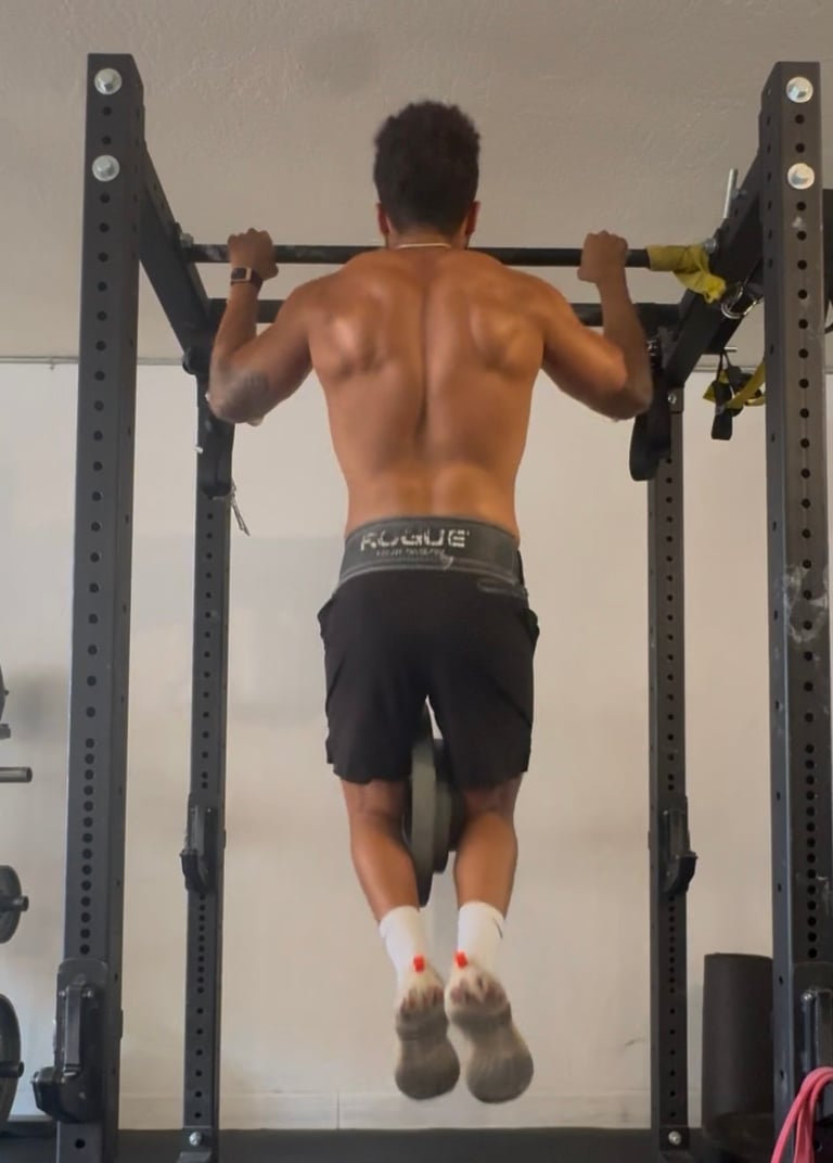Man performing pull-up on exercise rig in gym